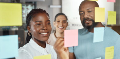 a black woman and black man discuss user insights in sticky notes