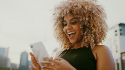 black woman agoes wow on mobile phone- emotion design masterclass